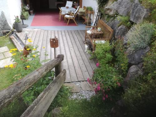 una terraza de madera con bancos y flores en un patio en Landhaus Gschmeidler, en Selzthal