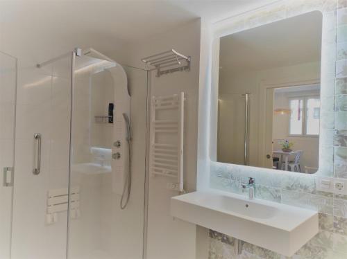 a white bathroom with a sink and a mirror at Kaixo MARINA in Zarautz