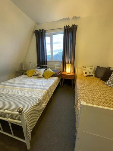 a bedroom with two beds and a window at Holiday home, Tywyn, newly refurbished, great location in Tywyn