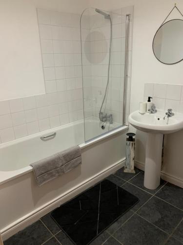 ein Badezimmer mit einer Badewanne und einem Waschbecken in der Unterkunft Slane Stay, Belfast in Belfast