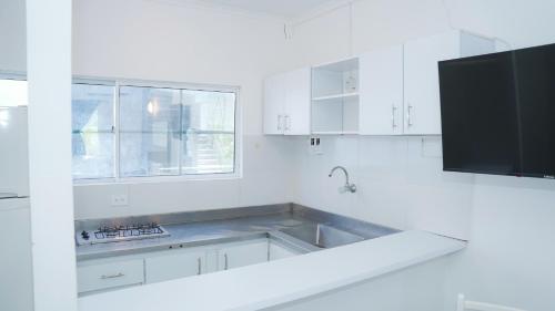 a white kitchen with a sink and a microwave at MAKARY BEACH HOTEL in Tolú
