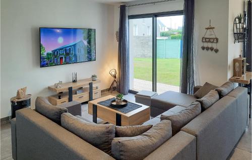 un salon avec un canapé et une télévision dans l'établissement 3 Bedroom Awesome Home In Plouguerneau, à Plouguerneau