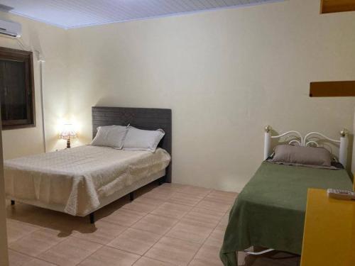 1 dormitorio con cama y manta verde en Barrinha dos Ventos, en São Lourenço do Sul