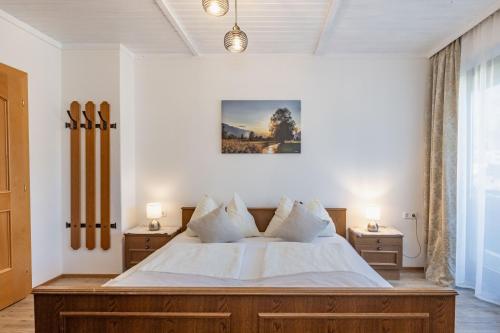a bedroom with a large white bed with two night stands at Gästehaus Nassfeld in Tröpolach