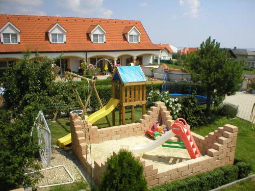 a play yard with a playground in front of a house at Appartementhaus Martina in Mörbisch am See