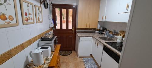 una pequeña cocina con armarios blancos y fregadero en Vivienda de uso turístico Domus Josefae, en Salamanca