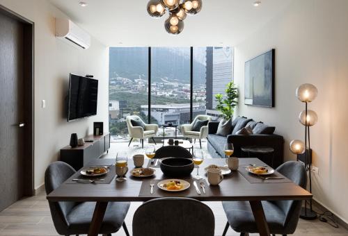 uma sala de estar com uma mesa e cadeiras e um sofá em 3 min de consulado EUA, nuevo, lujoso en Jardín Secreto 901 em Monterrey