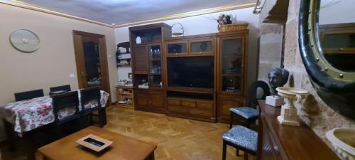 uma sala de estar com uma televisão e uma mesa em Vivienda de uso turístico Domus Josefae em Salamanca
