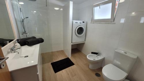 La salle de bains est pourvue d'un lavabo et d'un lave-linge. dans l'établissement Casa da Costureira, à Brejao