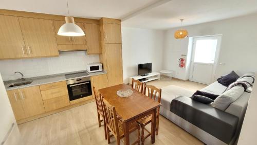 a kitchen and living room with a couch and a table at Casa da Costureira in Brejao