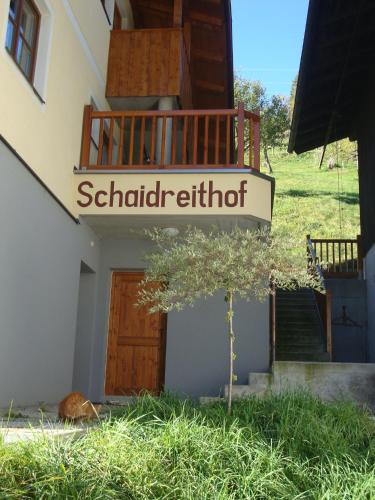 a small tree in front of a building with a door at Schaidreithof in Grossarl