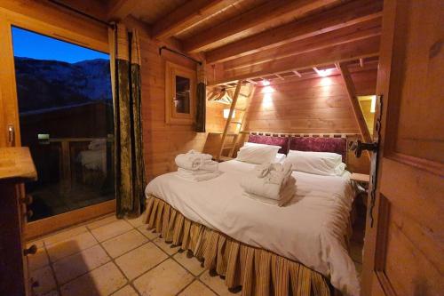 a bedroom with a large bed with towels on it at Cosy 4 bedroom chalet with hot tub (Chalet Velours) in Saint-Marcel