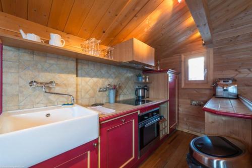 a kitchen with a sink and a stove at Cosy 4 bedroom chalet with hot tub (Chalet Velours) in Saint-Marcel
