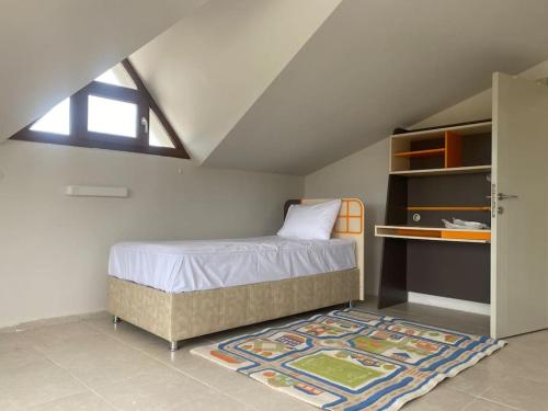 a bedroom with a bed with a window and a rug at Nefes URLA Villa Sea View. in Urla