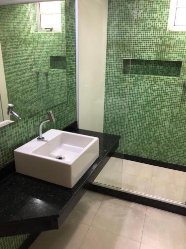 a bathroom with a sink and a glass shower at Hotel Serrano in Rio de Janeiro