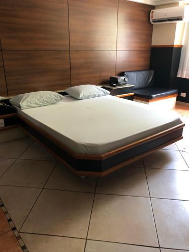Hotel Serrano في ريو دي جانيرو: سرير كبير في غرفة بجدار خشبي