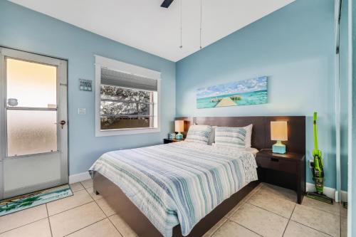 Dormitorio azul con cama y ventana en 53 Steps to Beach, en Clearwater Beach