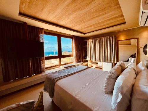 um quarto com uma cama grande e uma janela grande em POUSADA DO MIRANTE em Fernando de Noronha