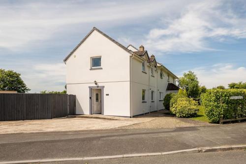 a white house with a fence in front of it at Ty Venda in Pembrokeshire