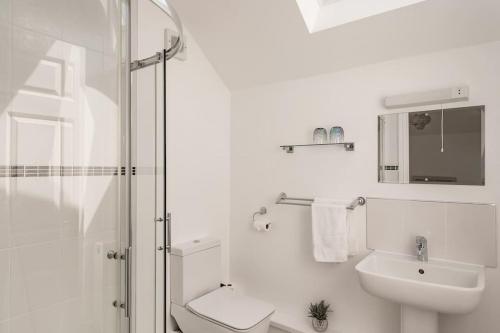 a white bathroom with a sink and a shower at Ty Venda in Pembrokeshire