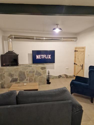 a living room with a couch and a sign that reads netflix at Aprosmeno Jacuzzi House 3 With Private Pool in Agros