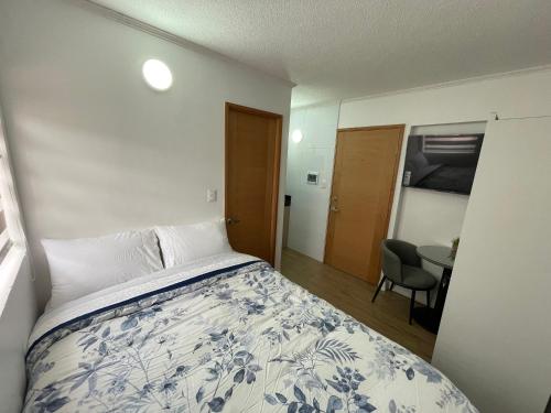 Un dormitorio con una cama y una mesa. en TinyApartments - estudio pleno centro Concepción, en Concepción