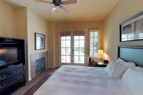 a bedroom with a bed with a ceiling fan and a television at LV022 Centrally Located Downstairs LV Studio in La Quinta