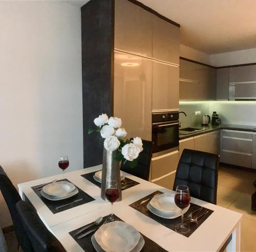a kitchen with a table with two glasses of wine at Downtown Apartments Monroe in Rzeszów