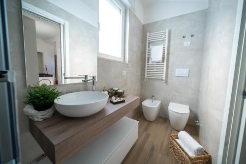 a bathroom with a large white sink and a toilet at Dimore Capirro Charming Family House in Trani