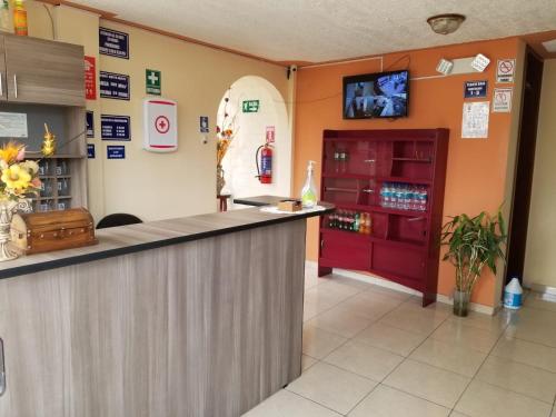 a bar in a restaurant with a tv on the wall at HOSTAL EL CONFORT QUITO NORTE in Quito