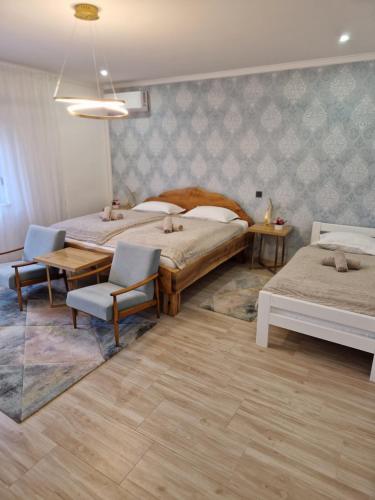 a bedroom with two beds and a table and chairs at Relax&Wine house Klara in Ruškovac