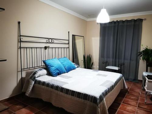 a bedroom with a bed with blue pillows on it at CASA ISA, ideal para descansar. in Santa Cruz de la Palma