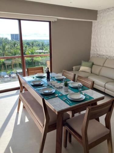 a dining room with a table and chairs and a couch at Casa Ohana Acapulco Diamante in Acapulco