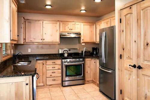 a kitchen with wooden cabinets and a stainless steel refrigerator at The Raspberry Garden in Rexburg