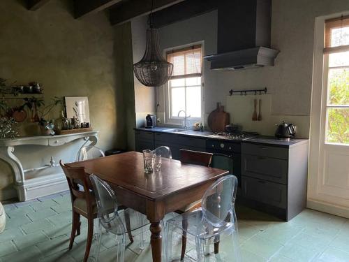 cocina con mesa de madera, mesa y sillas en Hofstede klein Rozendaal, huisje Rozen, en Asch