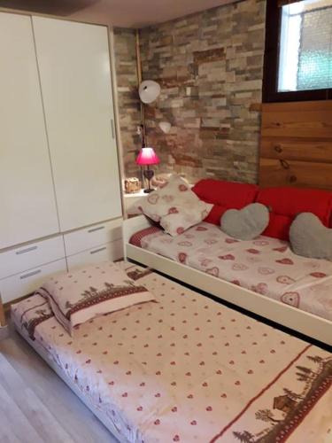 une chambre avec un grand lit avec une tête de lit rouge dans l'établissement at foot of Mont Blanc studio 2 p, à Cluses