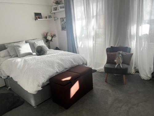 1 dormitorio con cama, silla y cortinas en Lovely 2 bed Hampstead Apartment en Londres