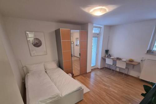 a small bedroom with a bed and a kitchen at Little cozy apt close to centre in Ljubljana
