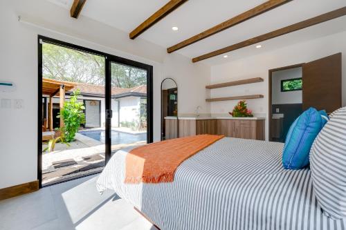 a bedroom with a large bed and a large window at Calle 1 - 29 Tamarindo in Tamarindo