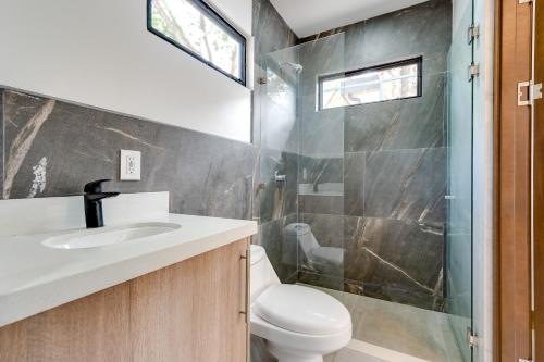 a bathroom with a toilet and a sink and a shower at Calle 1 - 29 Tamarindo in Tamarindo