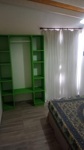 Departamento para 4 primer piso في فاليريا ديل مار: غرفة نوم مع رفوف خضراء وسرير