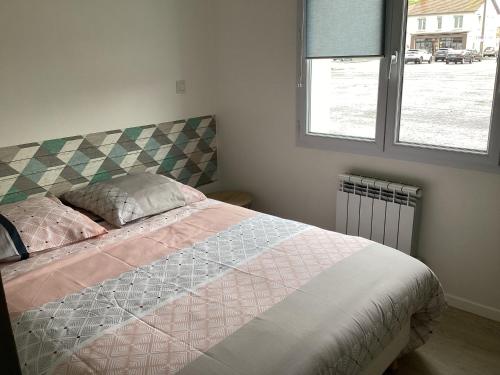 sypialnia z dużym łóżkiem i oknem w obiekcie Joli appartement 50 m2 classé 3 etoiles avec terrasse et jardin w La Rochelle