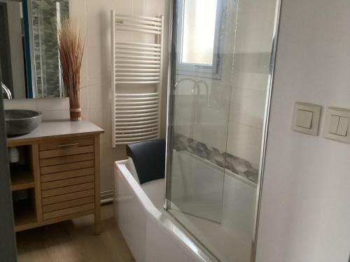 y baño con ducha y bañera. en Joli appartement 50 m2 classé 3 etoiles avec terrasse et jardin, en La Rochelle