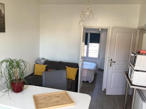 a living room with a couch and a kitchen at Chaleureux T2 30 m2 et sa terrasse bois 18 m2 in La Rochelle