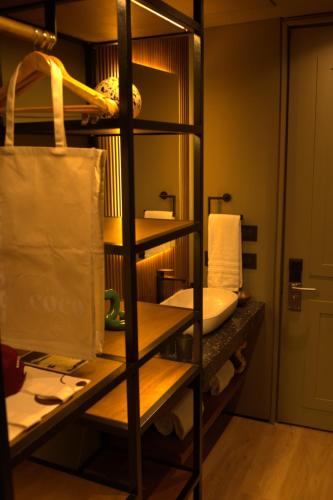 a bathroom with a shelf with a sink and a toilet at Hotel Coco in Bogotá