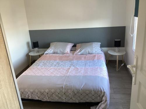 a bedroom with a bed with two tables at Chaleureux T2 30 m2 et sa terrasse bois 18 m2 in La Rochelle