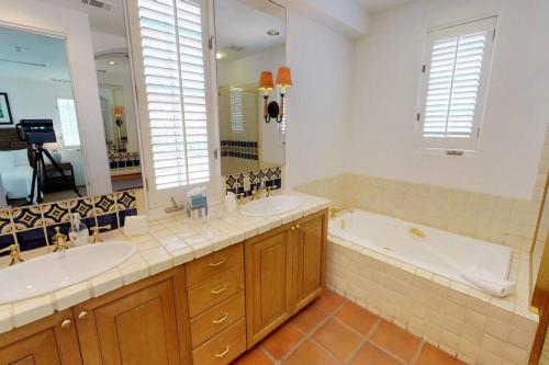 a bathroom with two sinks and a bath tub at SV006 Secluded Spa Villa Studio at LQ Resort in La Quinta