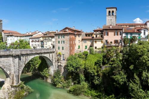 a bridge over a river with buildings in the background at Casa vacanza da Berto in Stregna