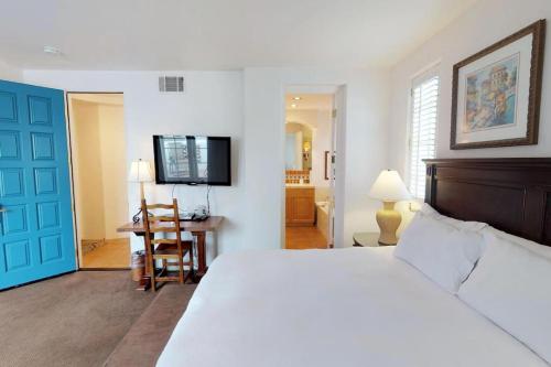 - une chambre avec un lit blanc et une porte bleue dans l'établissement SV108 1 Bedroom Spa Villa w Incredible Views, à La Quinta