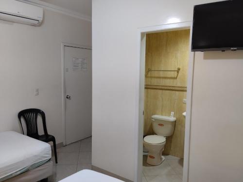 a small room with a bed and a toilet at Hotel Jeshua Simmonds in Guayaquil
